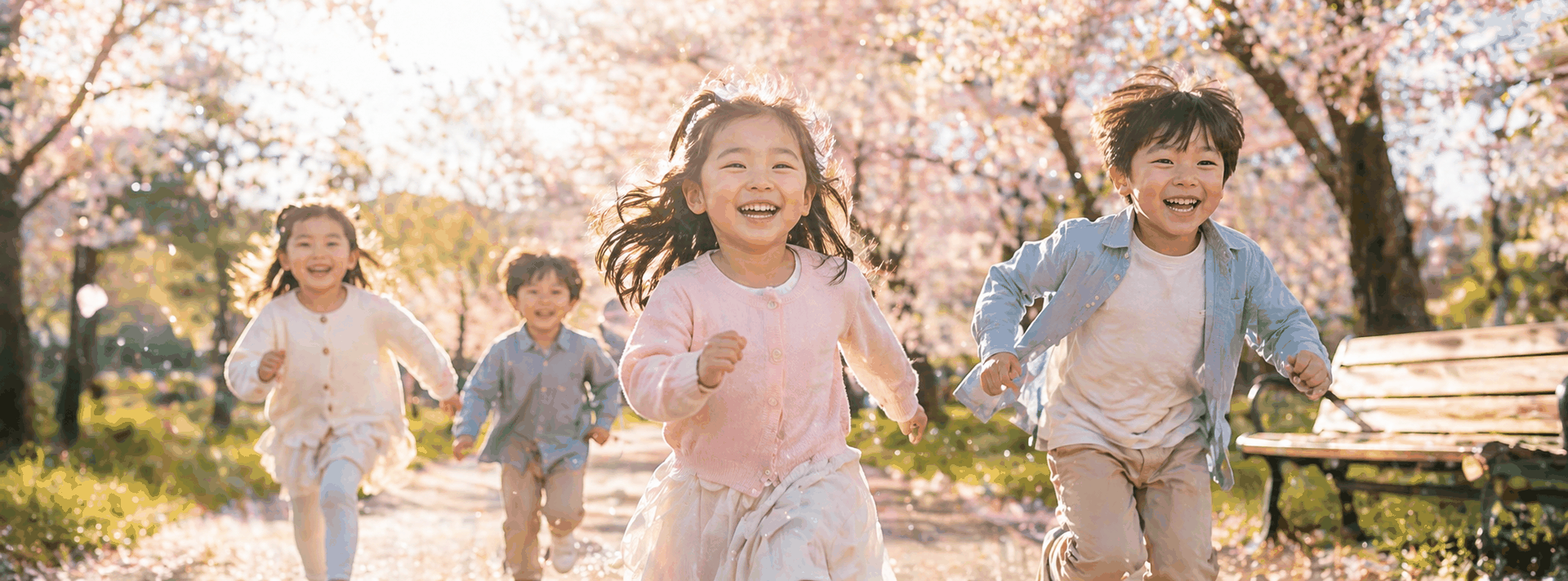 Children running through a spring park with cherry blossoms